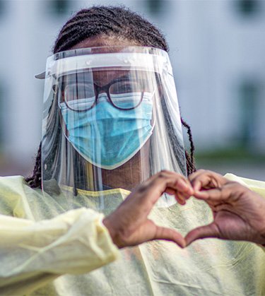 Nurse with heart hands and PPE