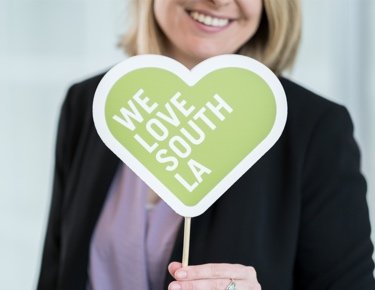 Woman holding "We love South LA" sign