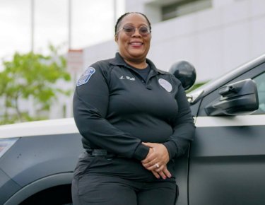 Lameka Bell standing against police car