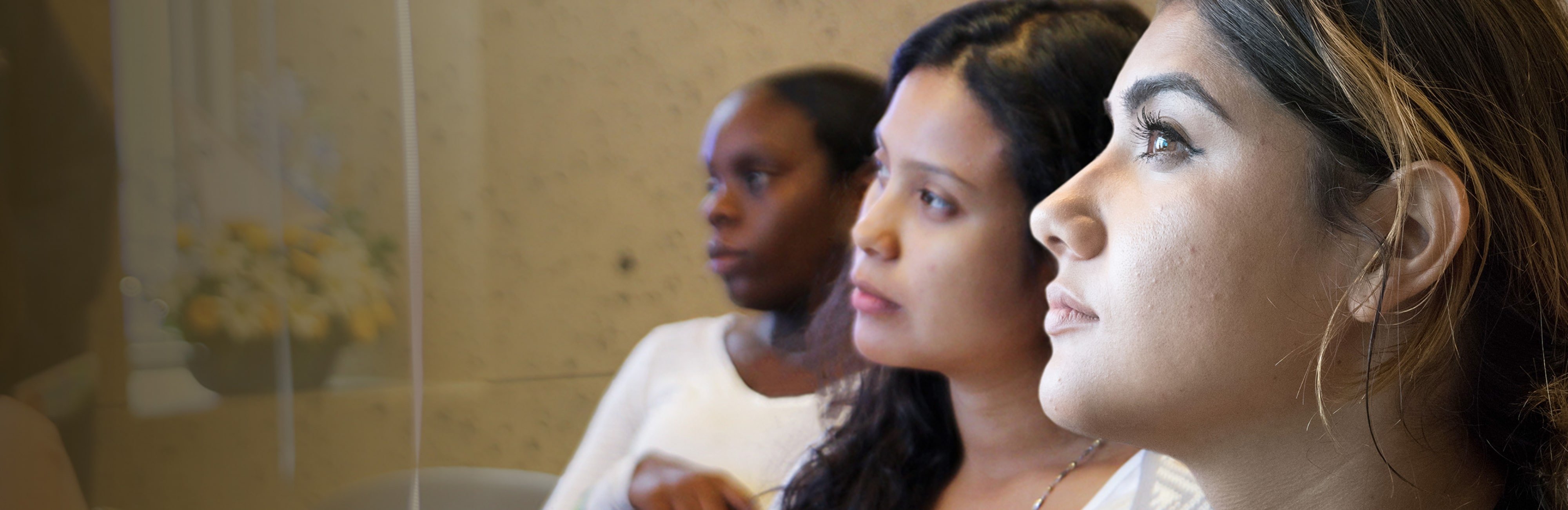 Young Latina woman in the foreground, with two women in the background