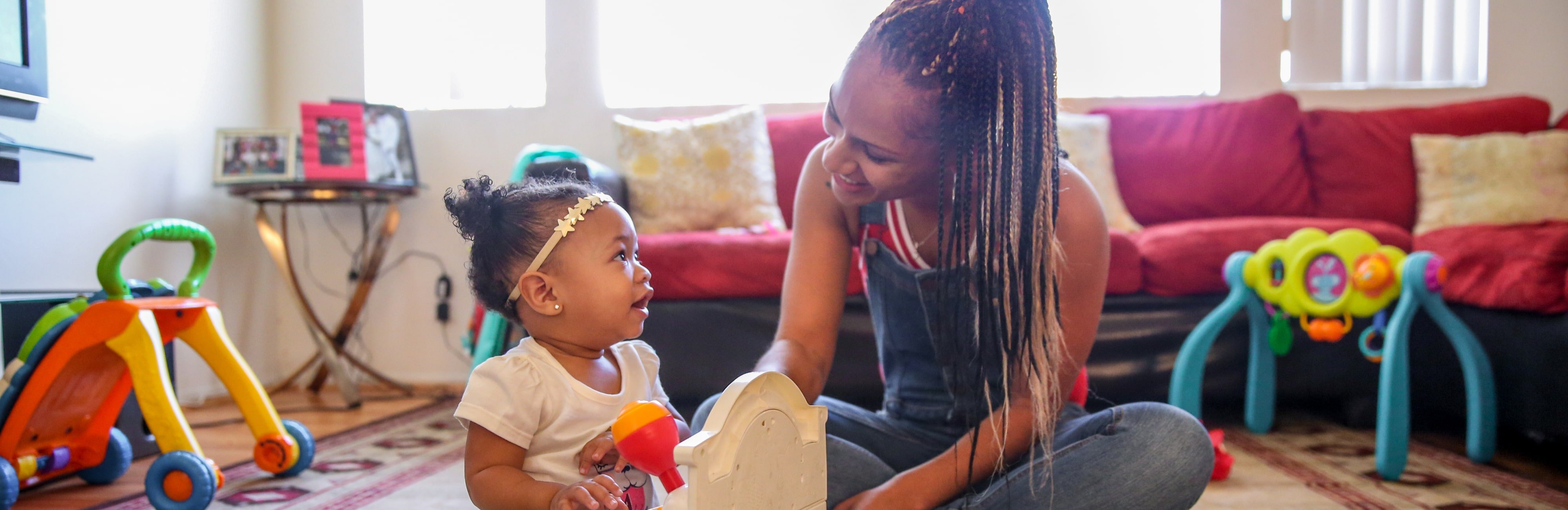 A smiling mother with her child playing on the floor