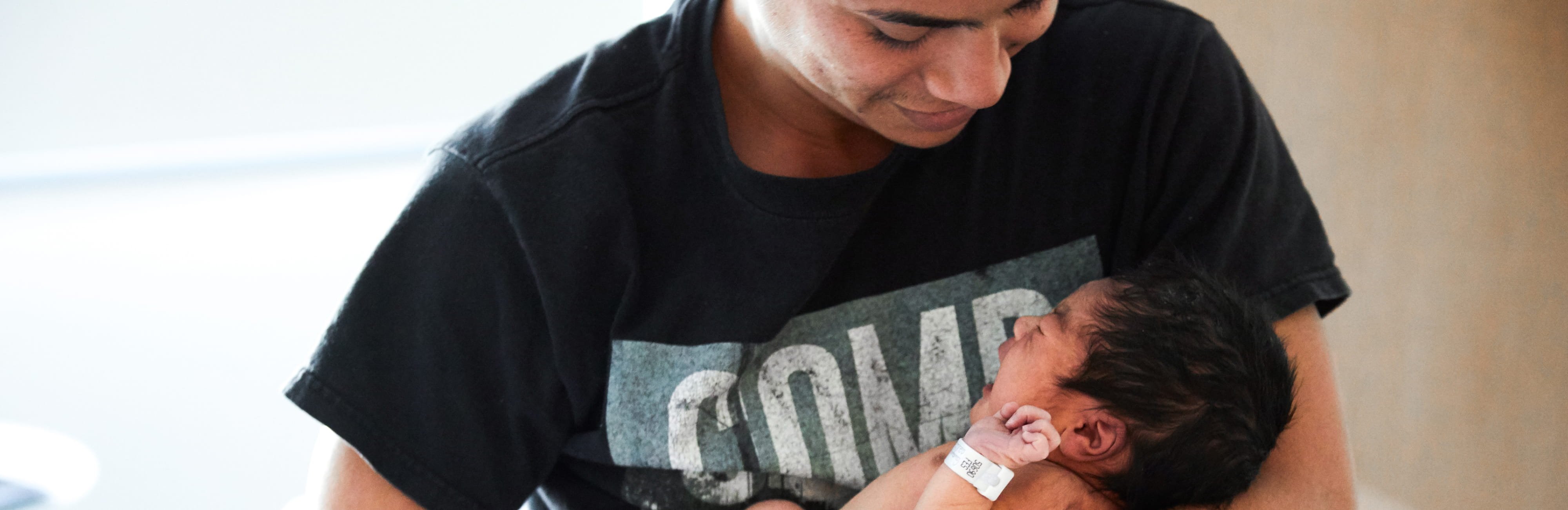 Dad holding and looking down at baby