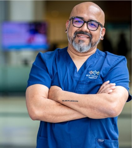 Photo of a male Hispanic nurse with glasses and arms crossed