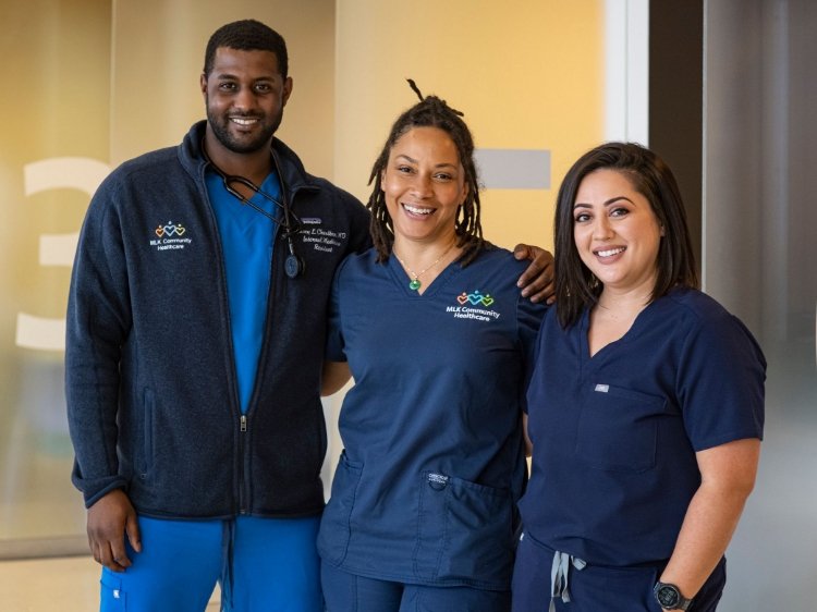 Photo of a male doctor with two female nurses (diverse)